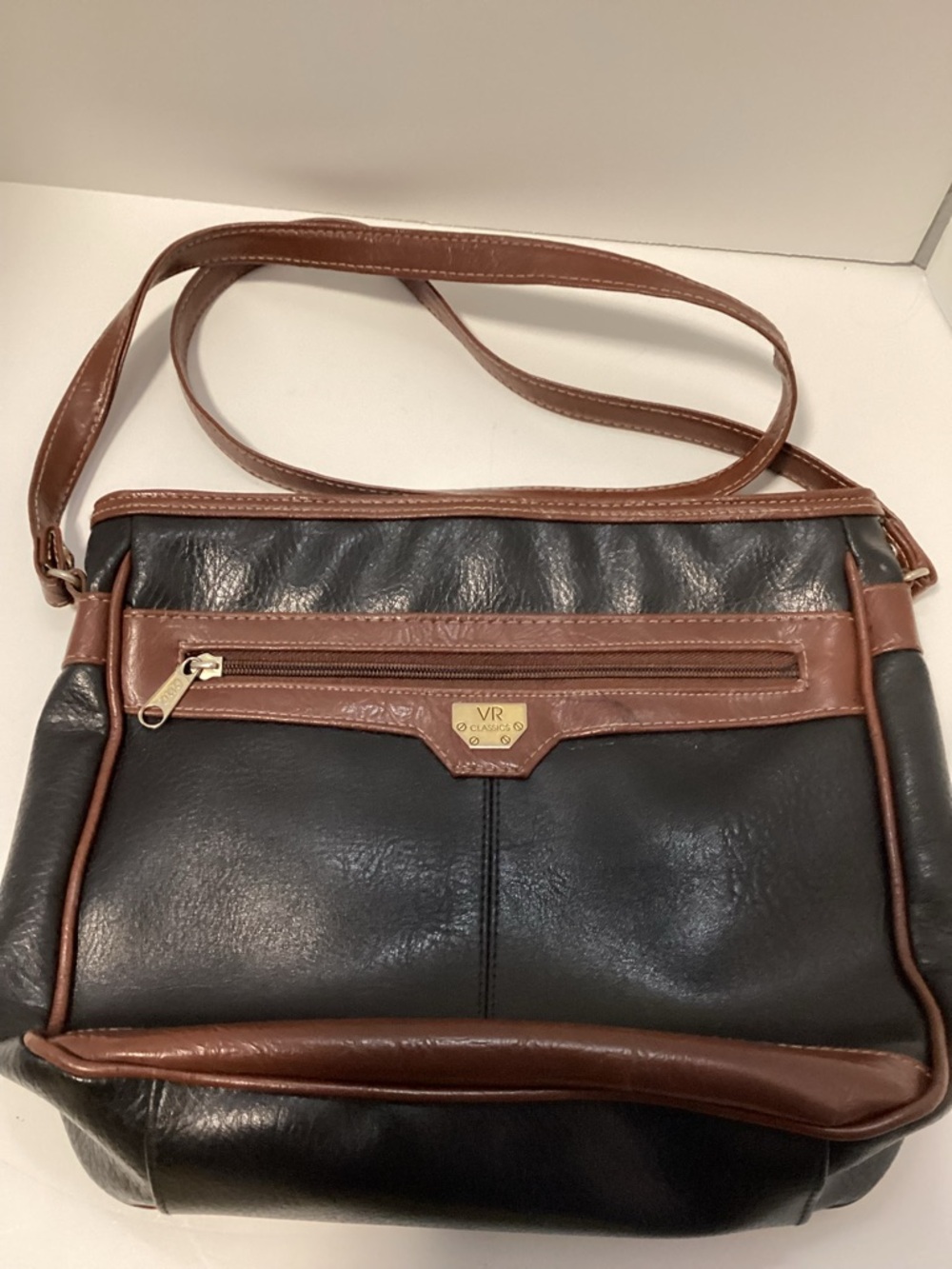 Black shoulder bag with brown trim and strap